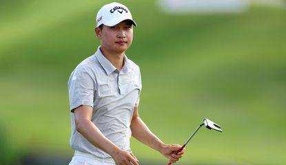 Jeunghun Wang walks on with his putter in hand