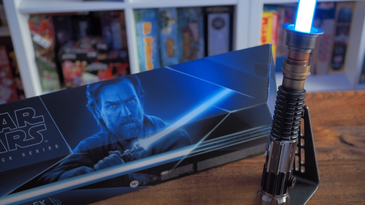 An ignited Obi-Wan Kenobi Force FX Elite Lightsaber on stand