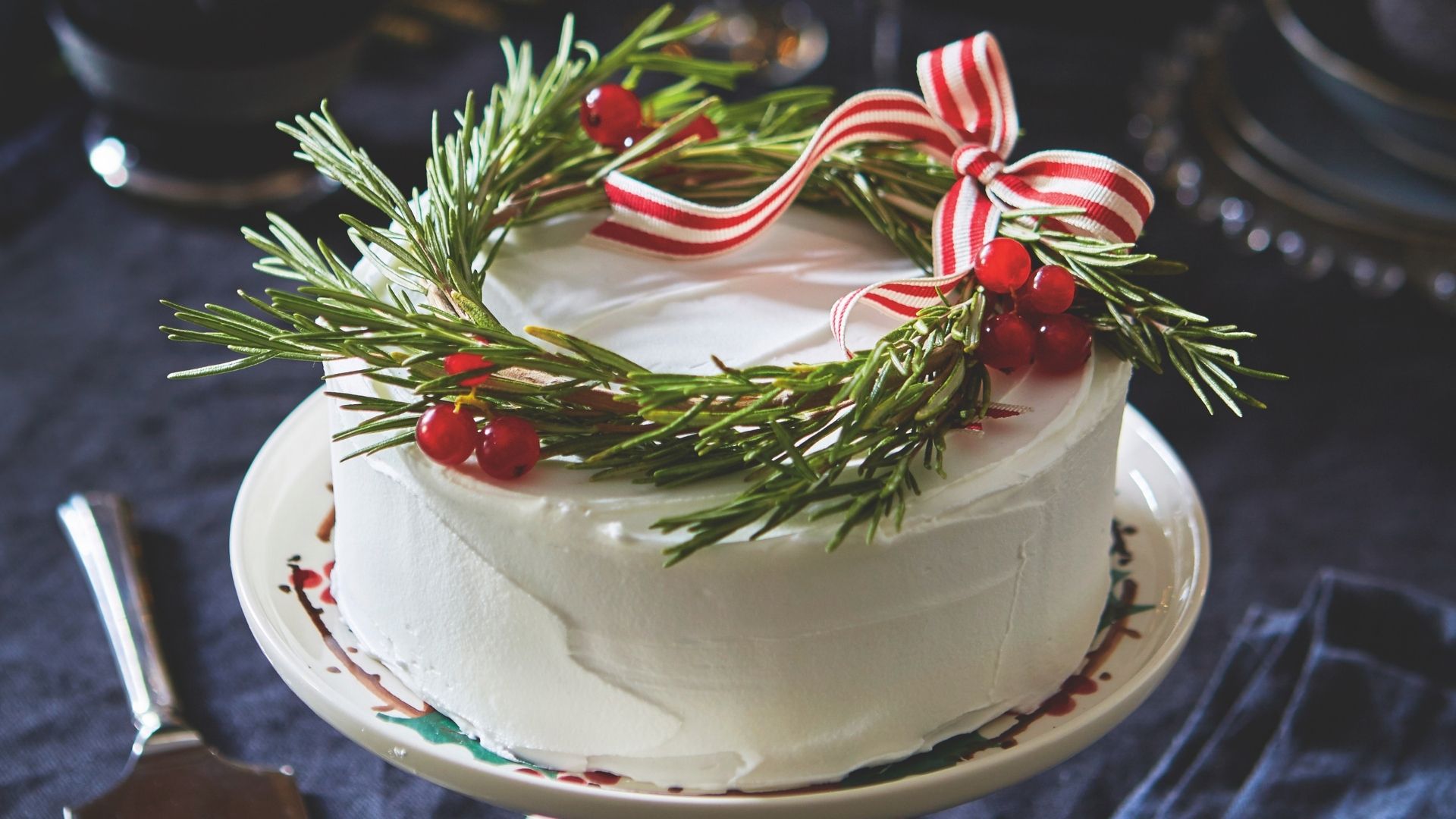 Irresistible Christmas Cake on a Christmas cake stand, rosemary decoration tied with ribbon