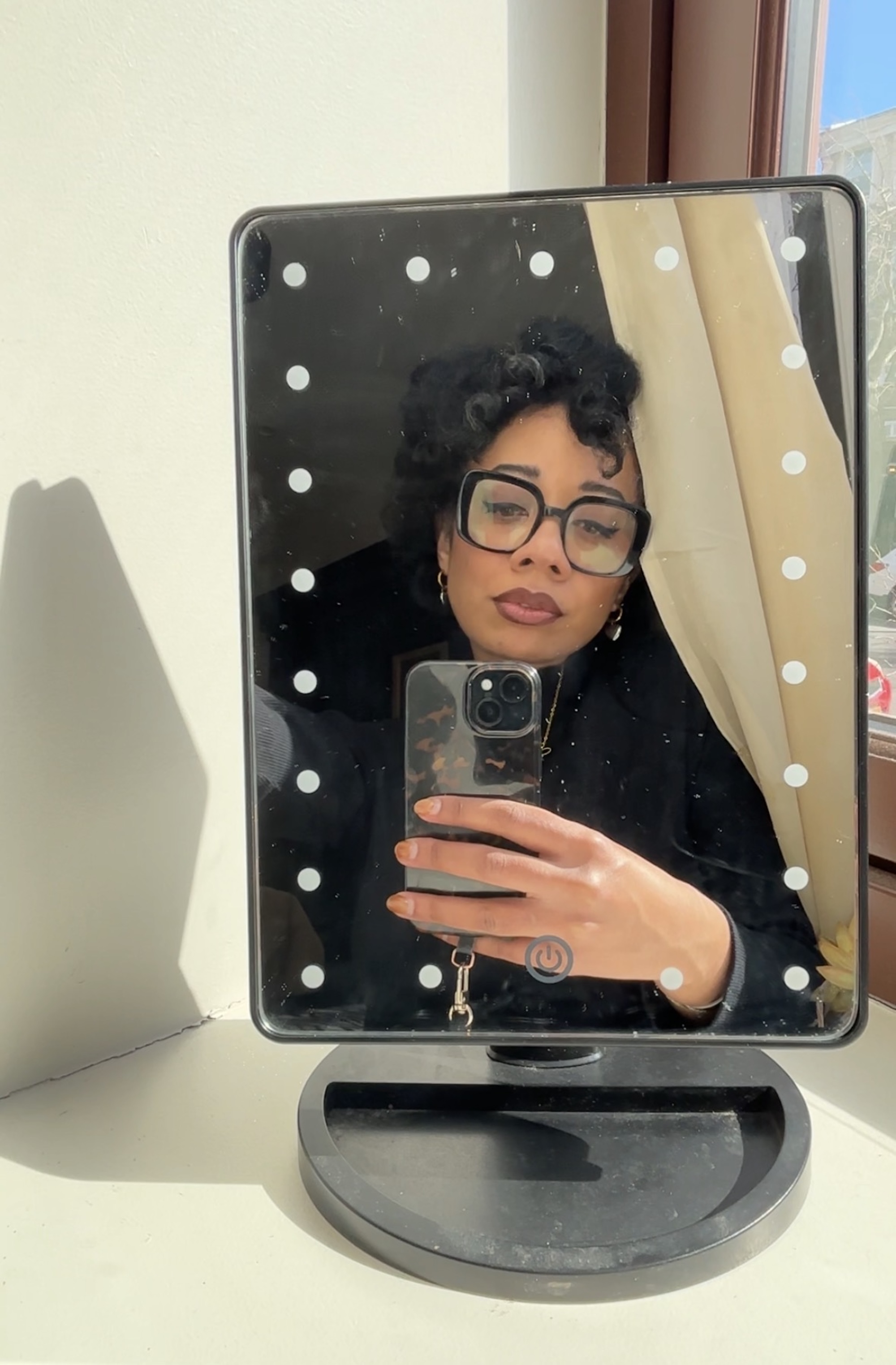 eden stuart taking a photo of her reflection in a makeup mirror