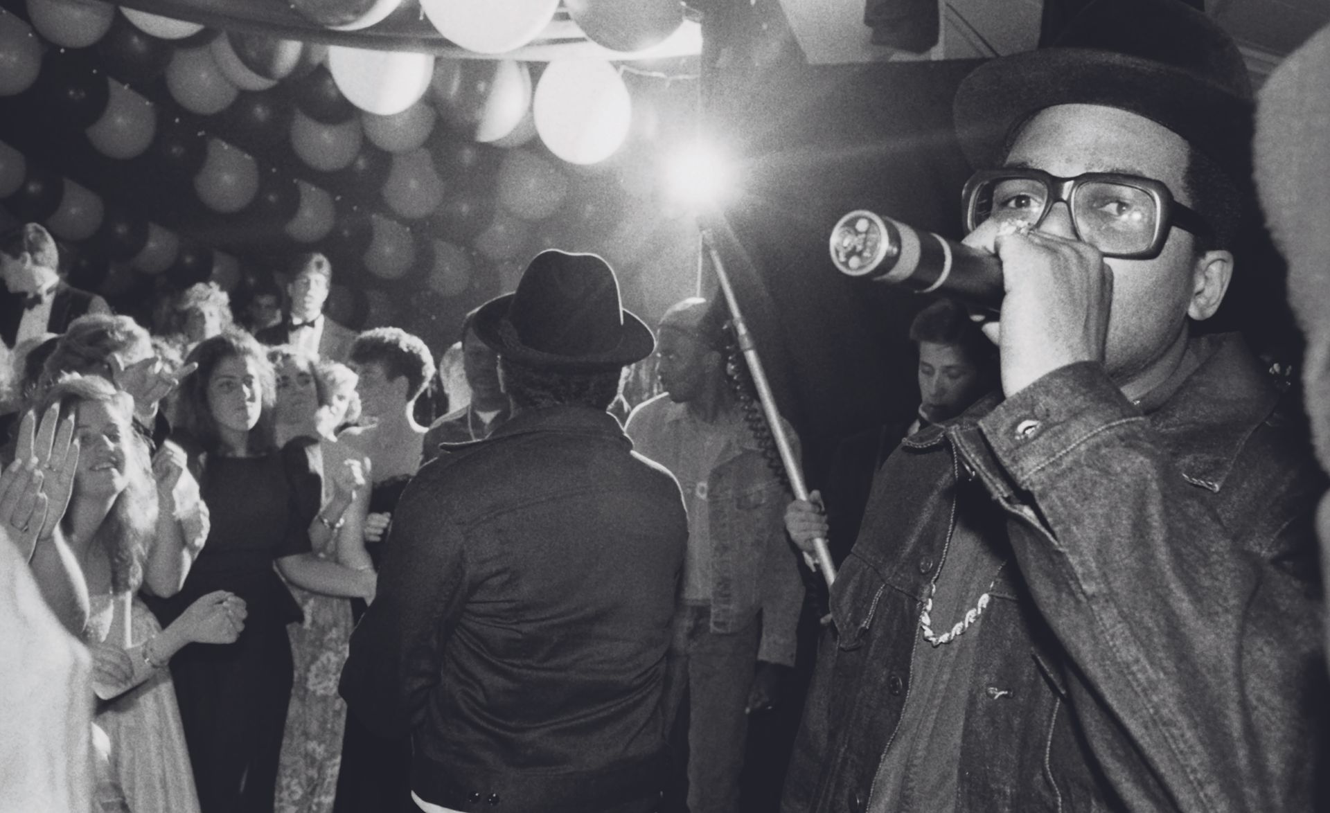 Man with mic at party, from pages of Rapper's Deluxe