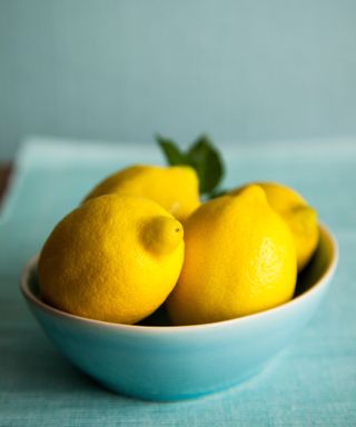 Lemons in a bowl on a wooden table