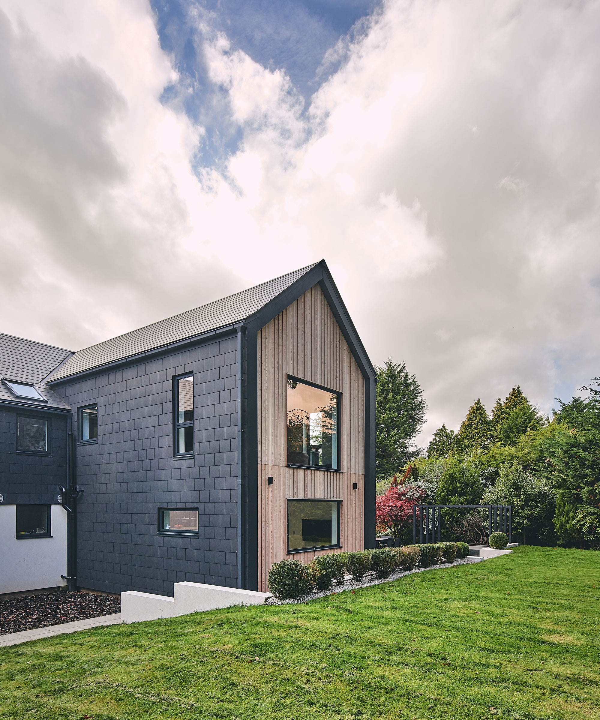 timber-clad self-build home with large lawned garden