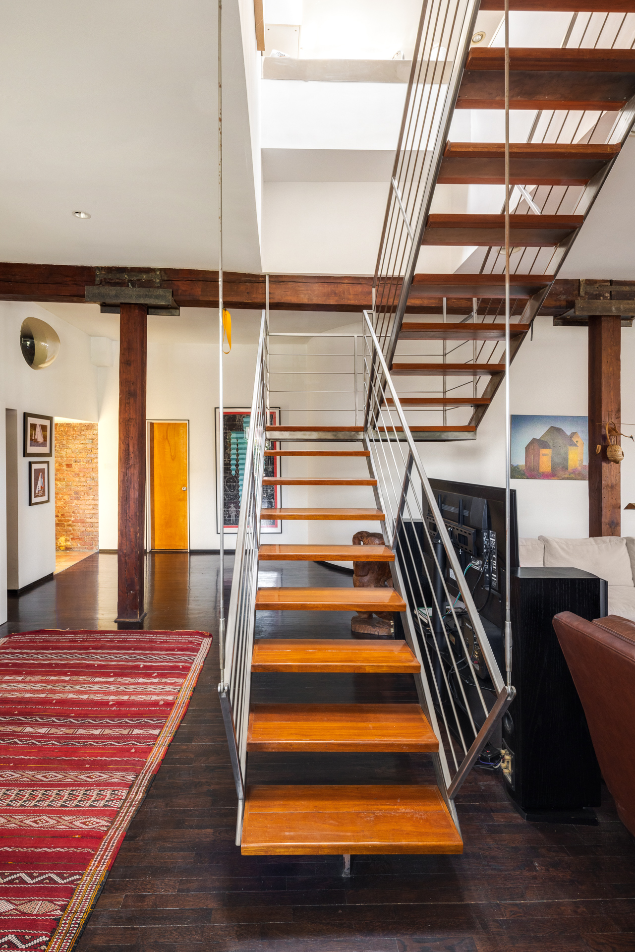 Details of the penthouse at 719 Greenwich Street, showing a characterful home with lots of wood, exposed brick, and fabulous views