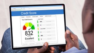 Man holding tablet on which a credit score is displayed.