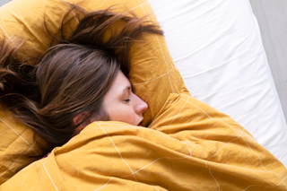 woman asleep in bed having vivid dreams during lockdown