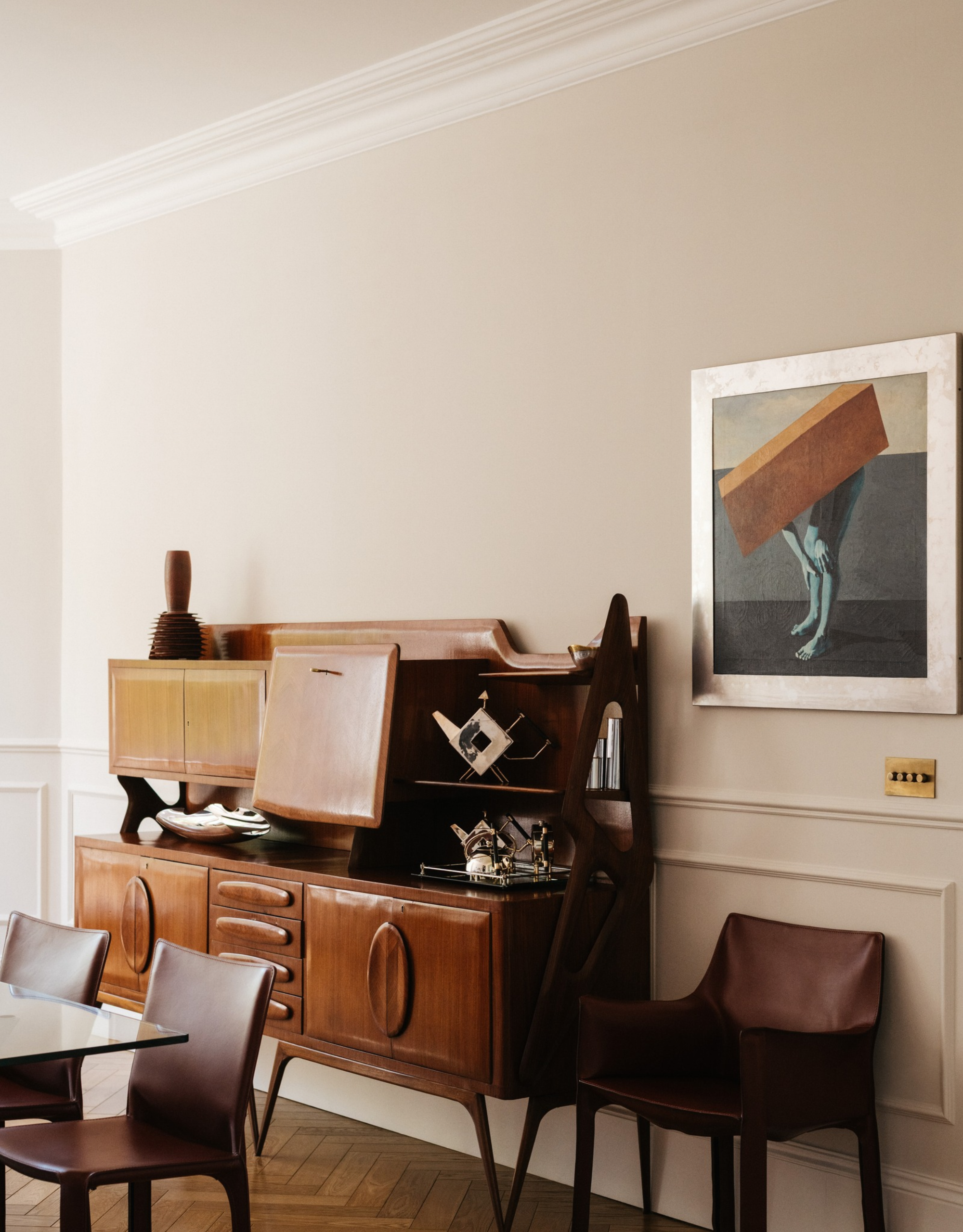 neutral and light living room with mid century wooden cabinet and leather dining chairs
