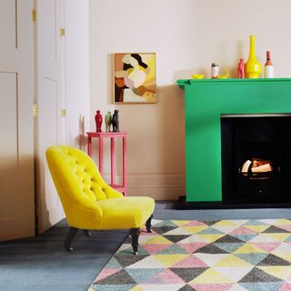 bold green fireplace with geometric rug and yellow armchair