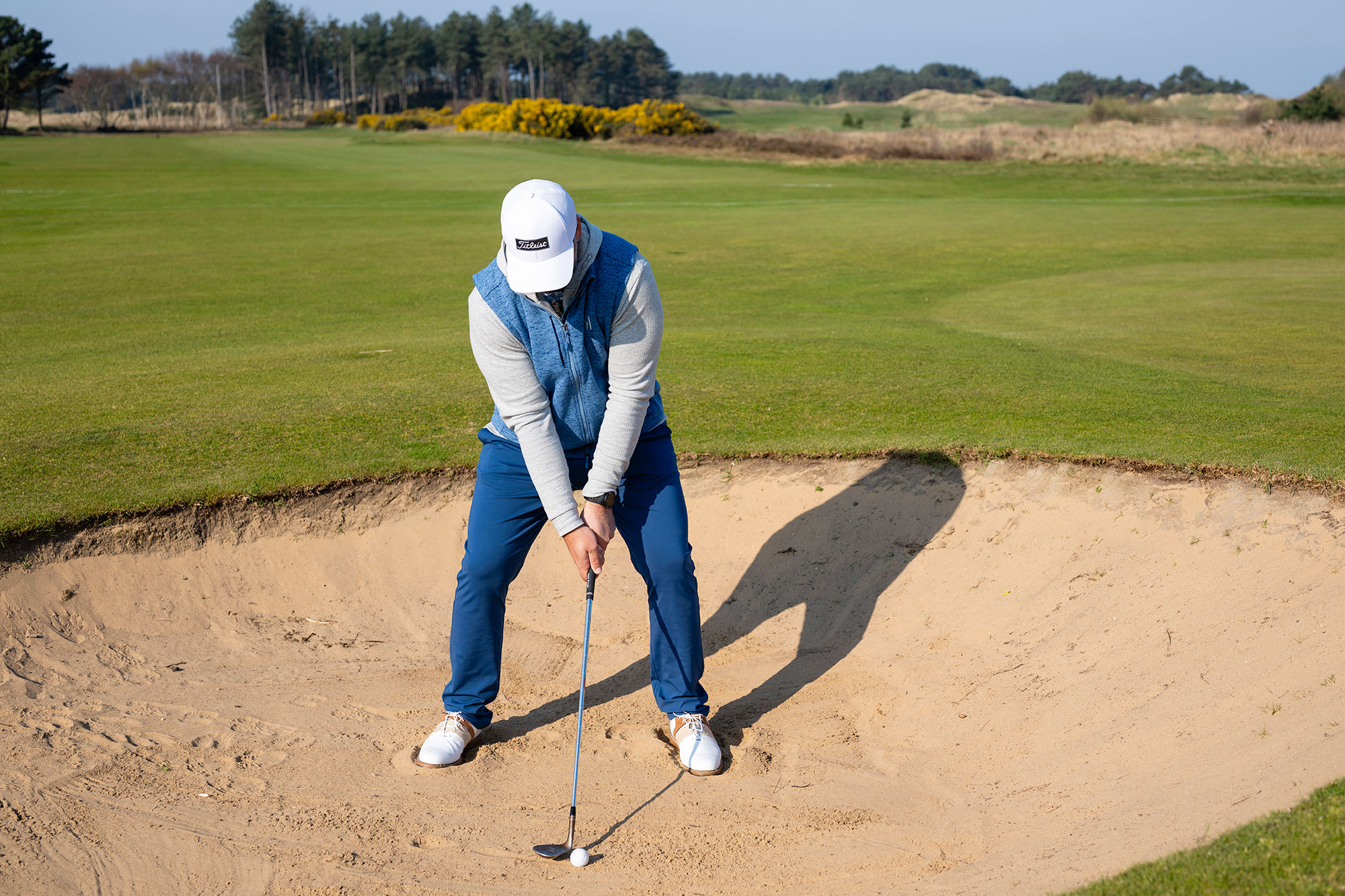 Peter Finch at setup for a greenside bunker shot, with the clubface open behind the golf ball