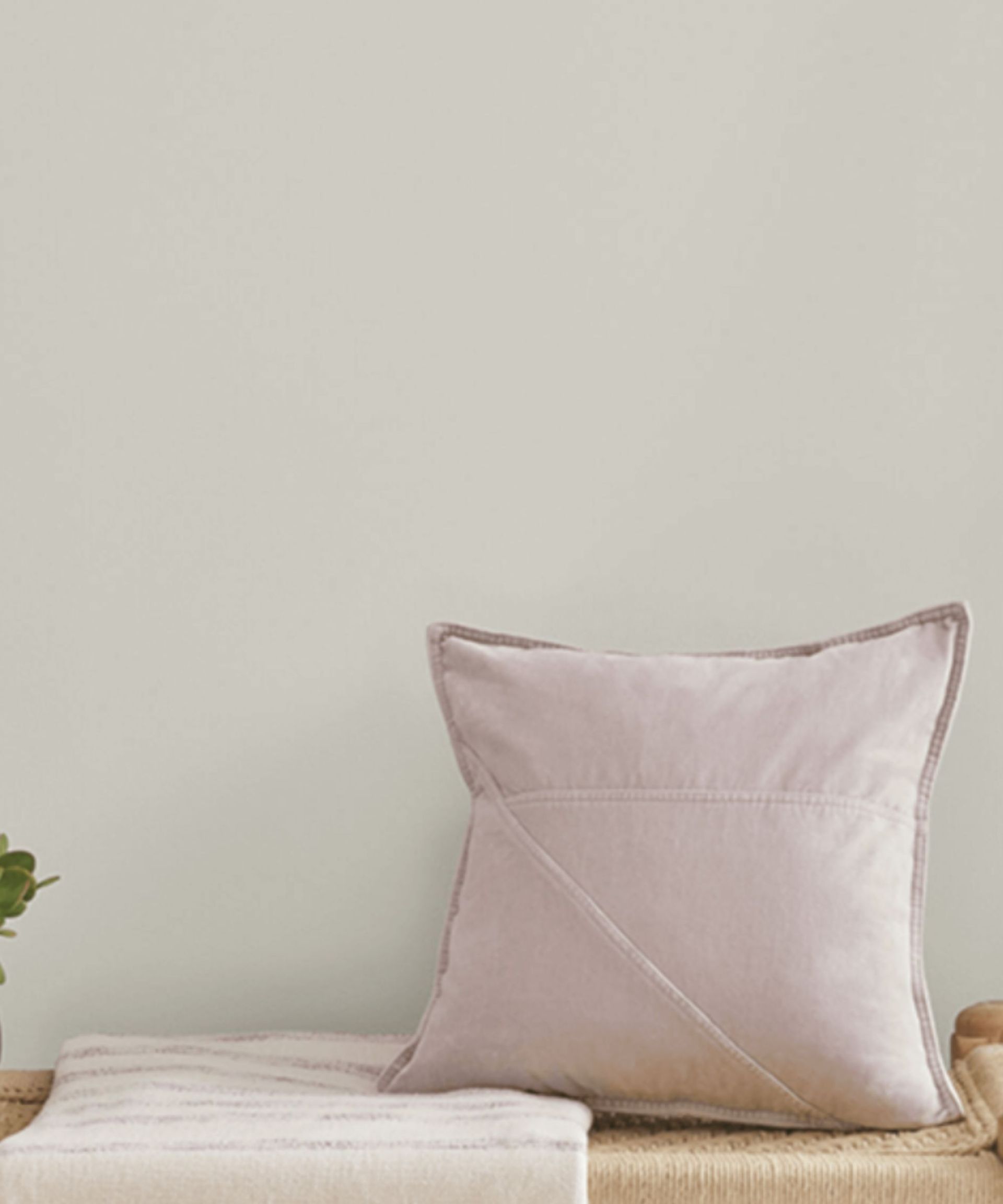 A wall painted in sherwin williams repose gray with a dusky pink velvet cushion on a bench