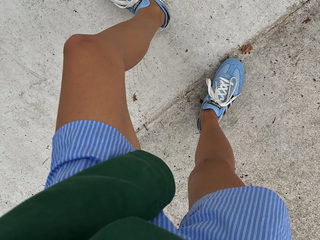 Woman wearing boxer shorts with sneakers.