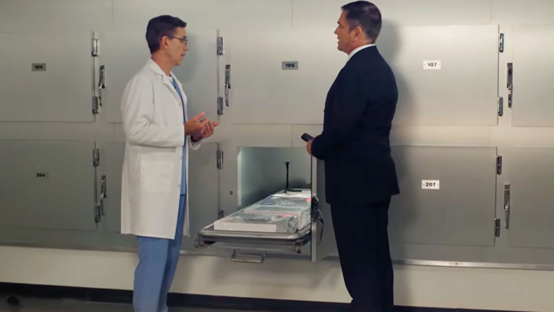 Jimmy and Tony in the morgue with a bunch of birthday cakes sitting in the freezer with them.