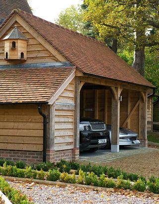 This oak frame cart shed by Border Oak has open bays and a log store