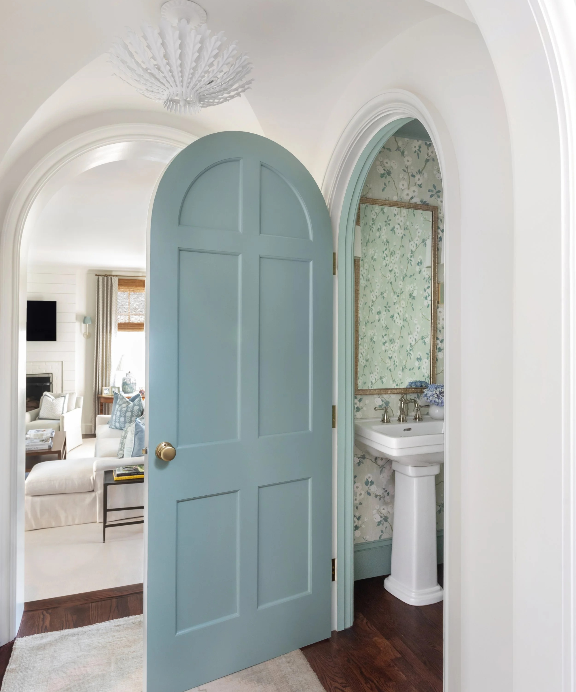 a blue door that leads into a bathroom in a white hallway