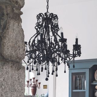 room with white wall and black coloured chandelier