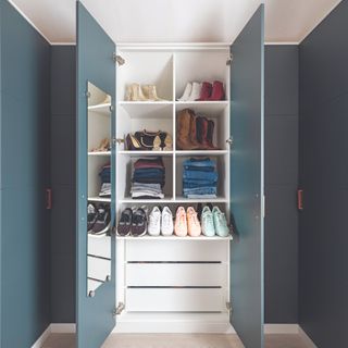 Navy blue walk-in wardrobe with white shelves