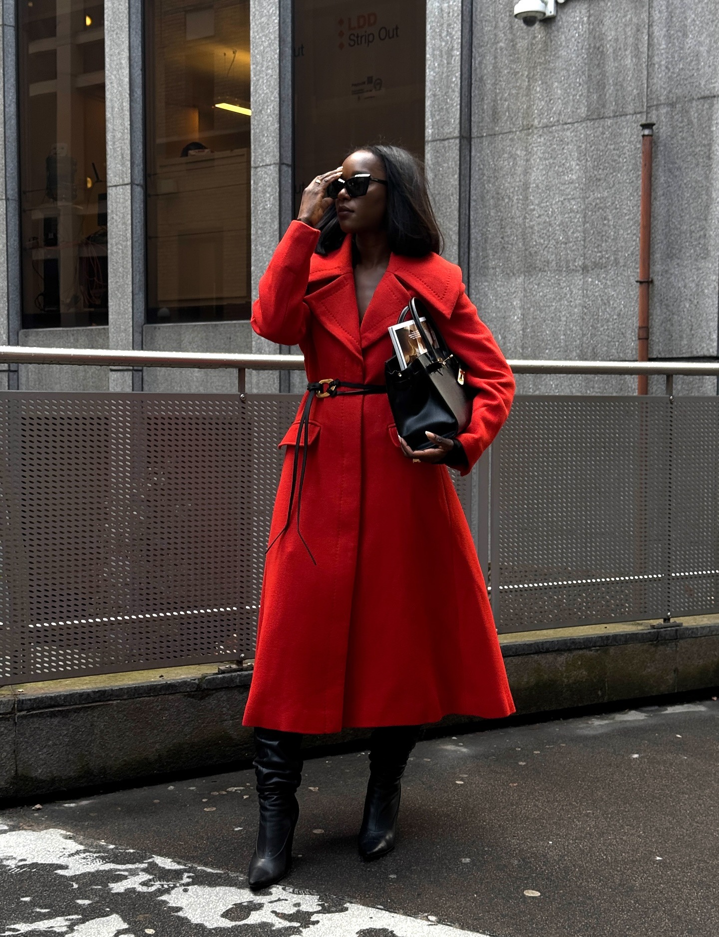 Style blogger Flora in a red wool coat with knee-high black boots and handbag.