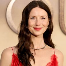 Caitriona Balfe attended the final Outlander premiere in a tomato red Louis Vuitton take on the lace-trimmed slip dress trend