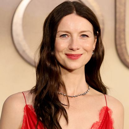 Caitriona Balfe attended the final Outlander premiere in a tomato red Louis Vuitton take on the lace-trimmed slip dress trend