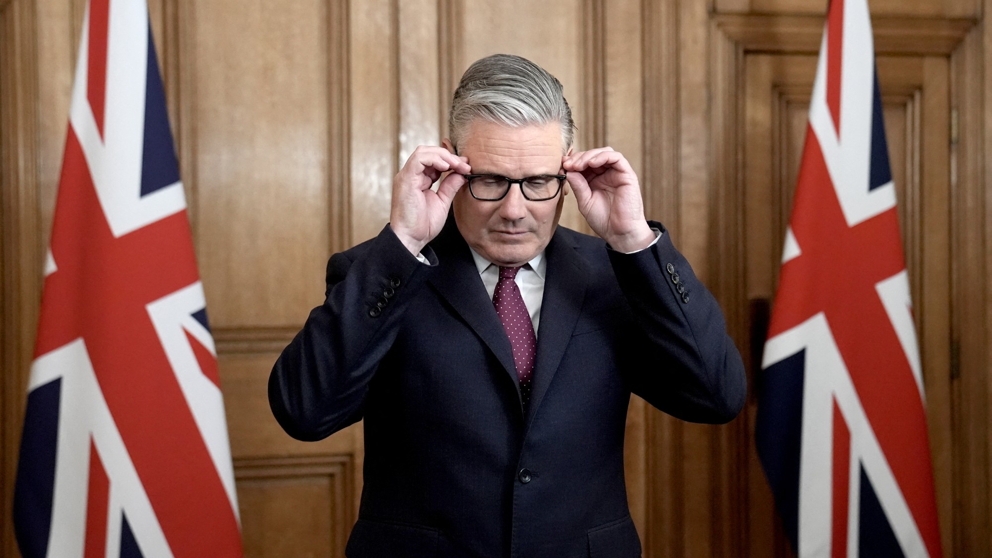 Keir Starmer adjusts his glasses before speaking during a pooled TV clip inside 10 Downing Street