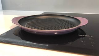 A cast iron grill pan on a glass stove