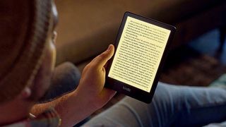 A man reading on the Amazon Kindle Paperwhite 2021 with the screen light adjusted to warm hues