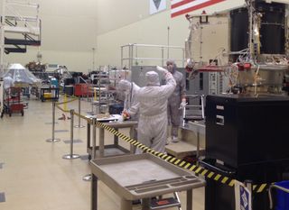 Busy builders of spacecraft missions. Lockheed Martin technicians are readying asteroid mission in a large ultra-clean room (foreground) as workers prepare the Insight Mars lander — in background — that will head for the Red Planet in 2016.