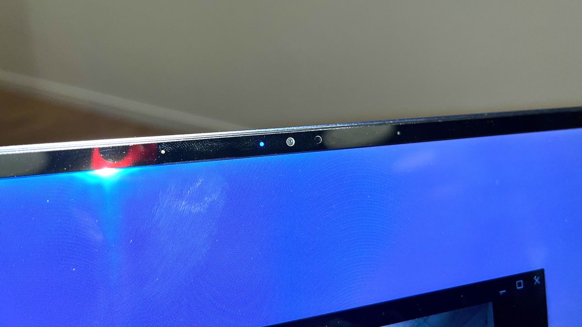 Close up of the webcam on the Samsung Galaxy Chromebook Plus, against a white wall.