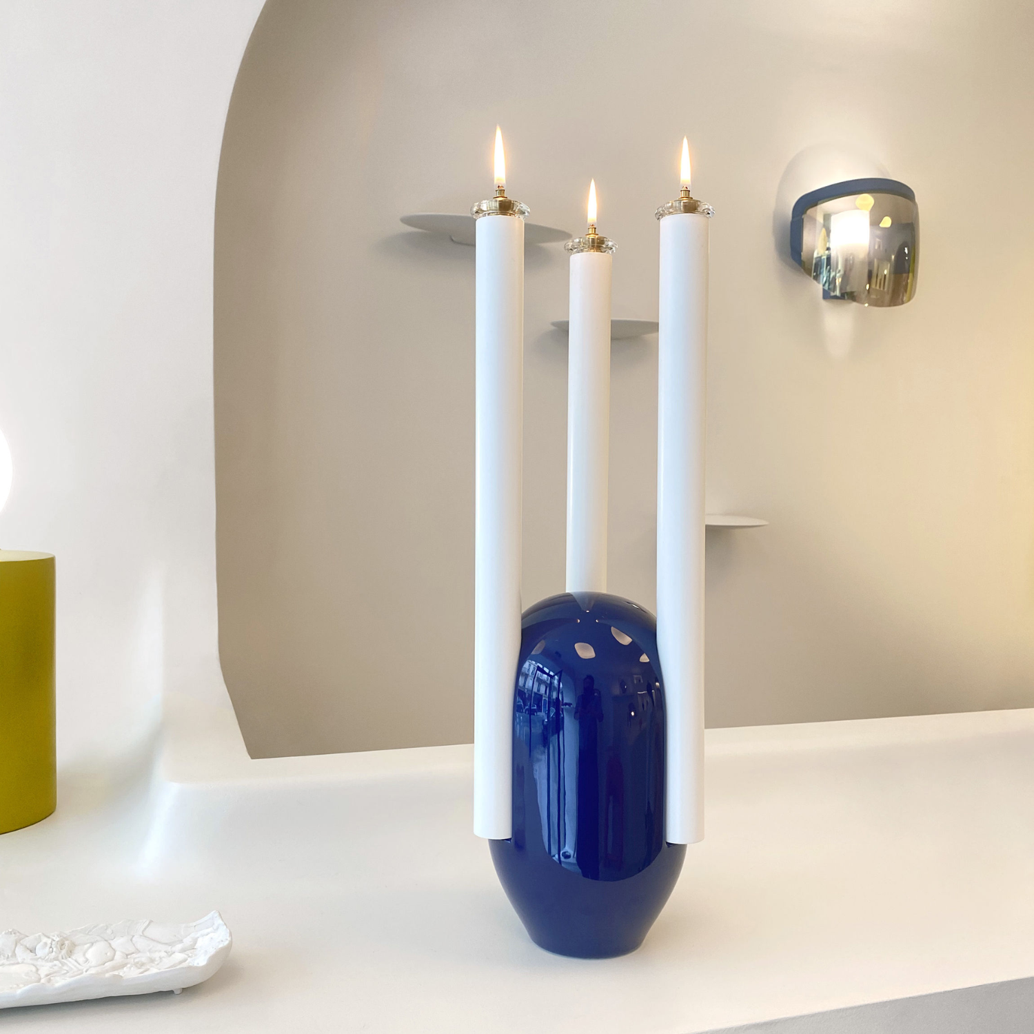 A blue oil lamp with three white candles