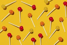 Yellow, red and orange lollipops against a yellow background.