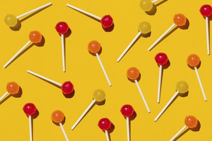 Yellow, red and orange lollipops against a yellow background.