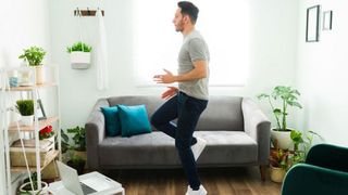 Man performs high knees exercise at home