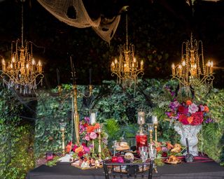 halloween outdoor dining set-up with gothic accessories and lighting