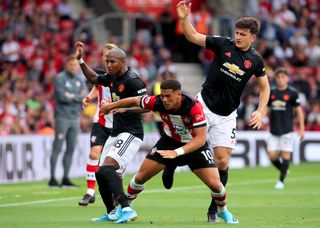 Southampton’s Che Adams (centre) clashes with Ashley Young (left) and Maguire