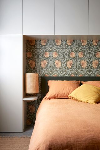 A bedroom with soft orange bed linen