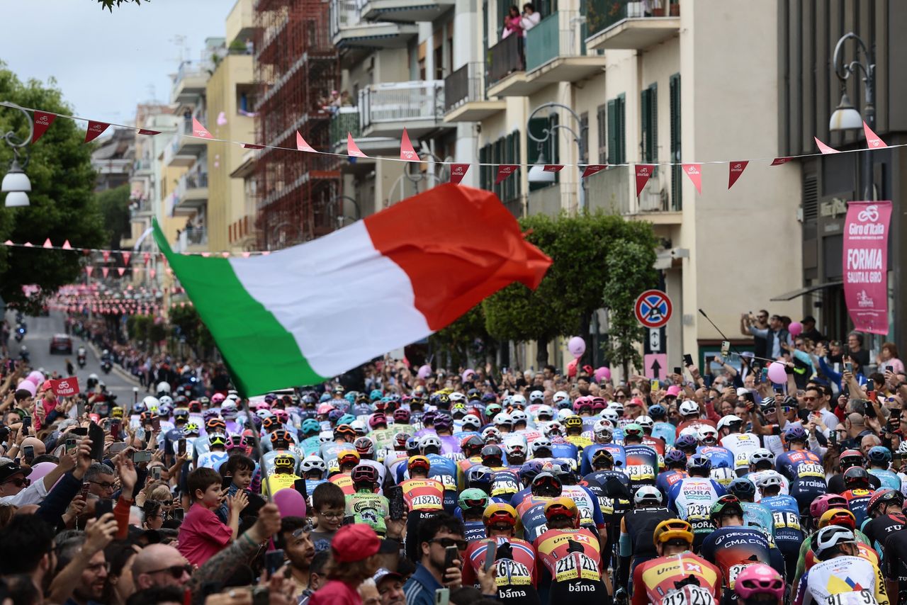 Giro d'Italia peloton rides underneath Italian flag