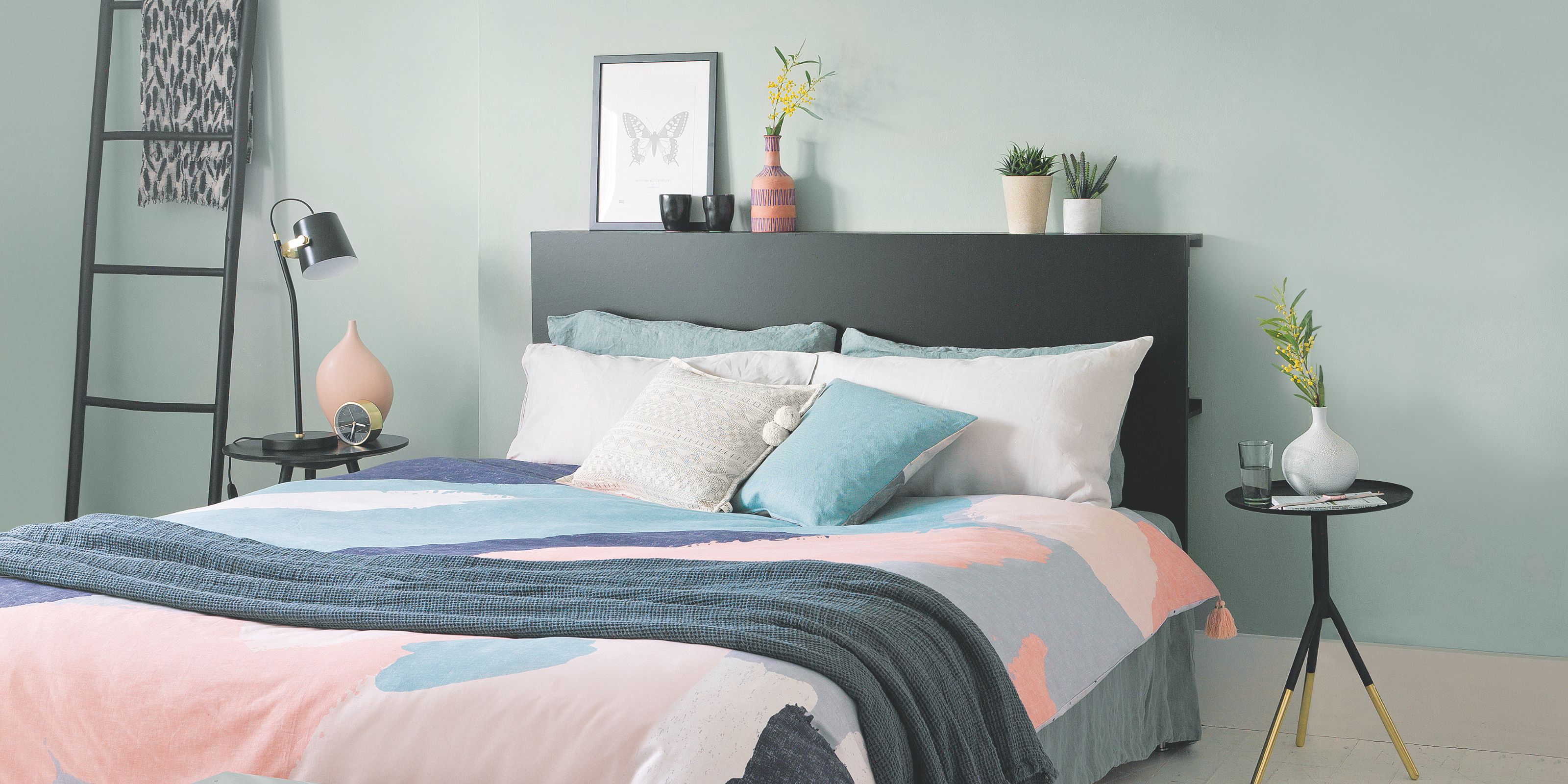 a bedroom with blue walls and pink bedding