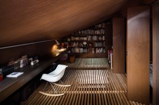 The floor of the study is made of wooden slats to allow light from a large window upstairs down through the entire house