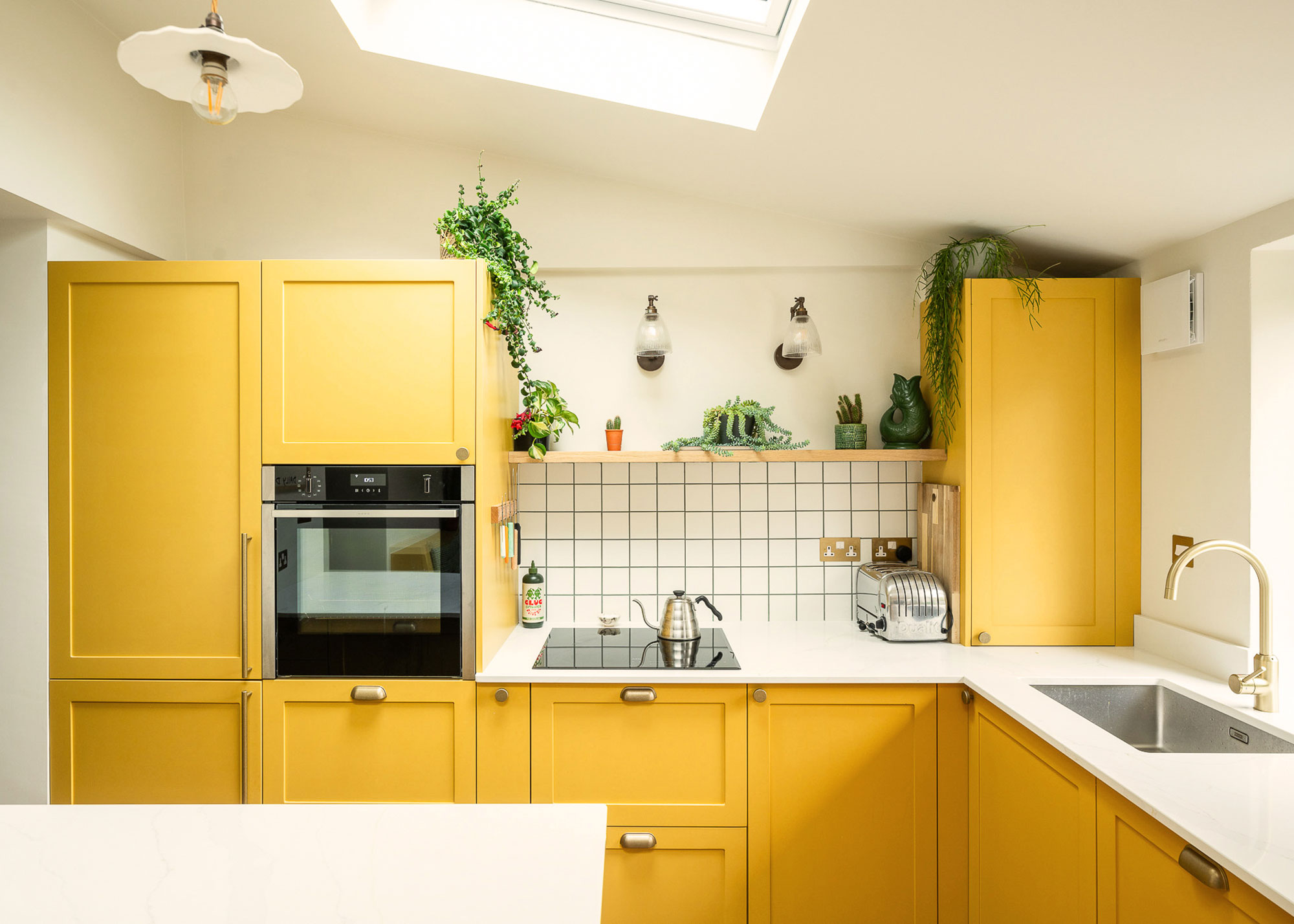 bright yellow Shaker kitchen with white worktops and white tiled splashback
