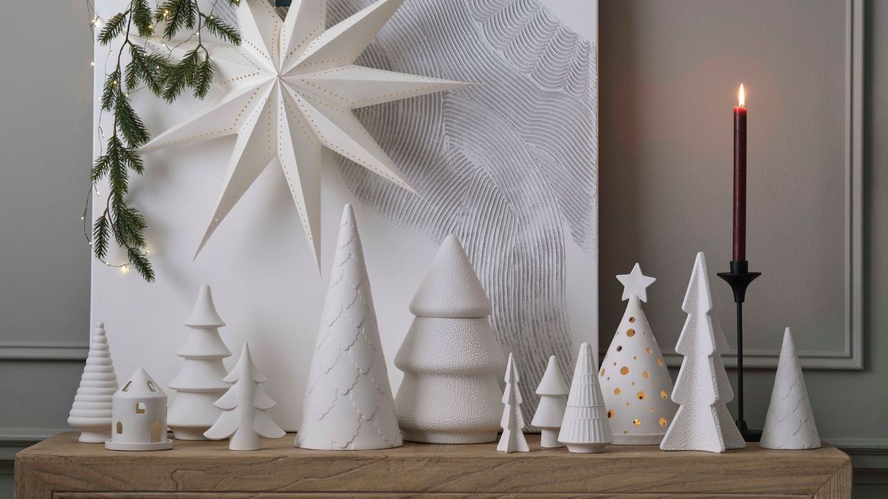 Ceramic chite christmas tree decor pieces on a sideboard