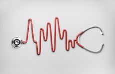 stethoscope on white background with red cable shaped like a heart monitor