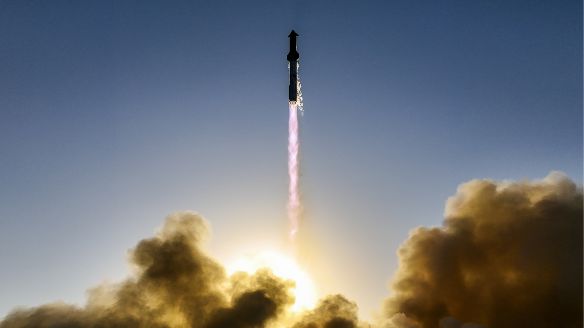 a huge rocket launches into a blue sky