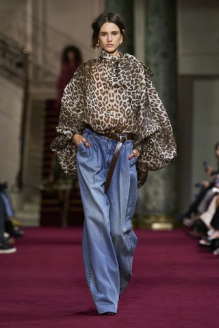 Woman on Zimmerman runway in leopard print blouse and jeans