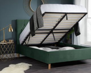An open green velvet ottoman bed in bedroom