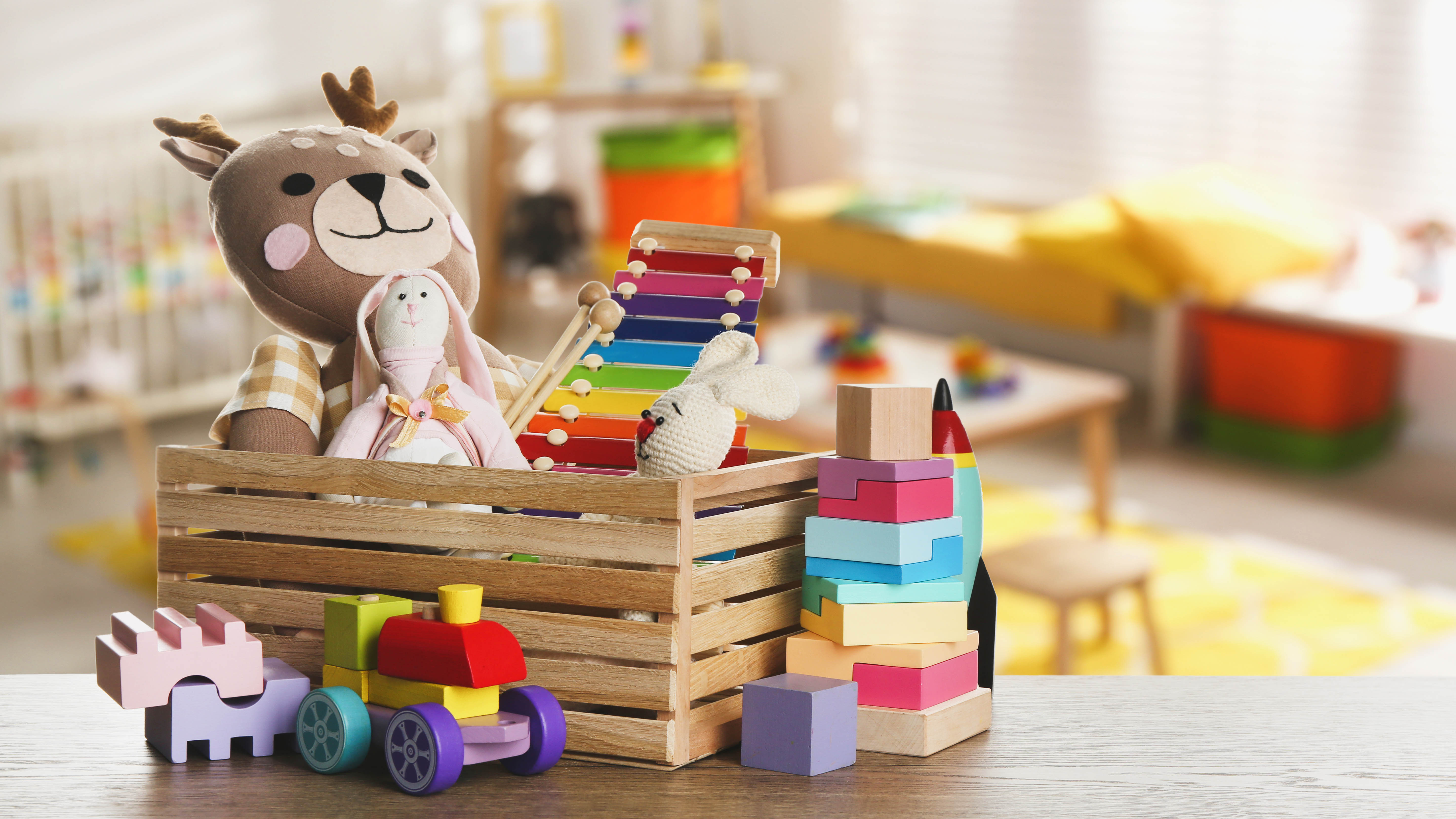 Коробка детских игрушек, включая мягкие игрушки.