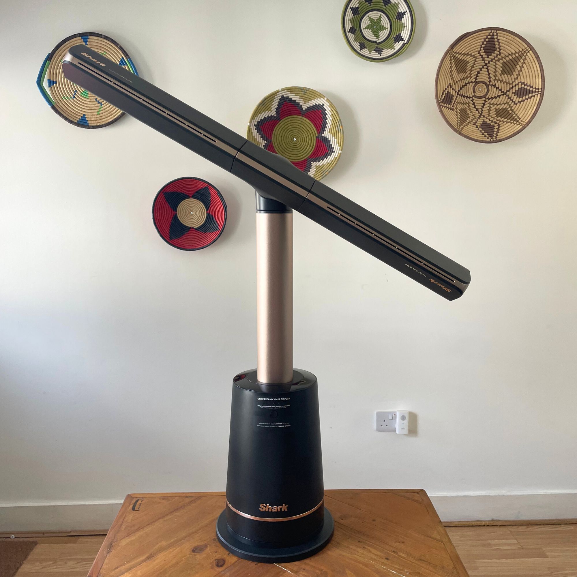 Shark TurboBlade fan on a wooden table in front of a white wall