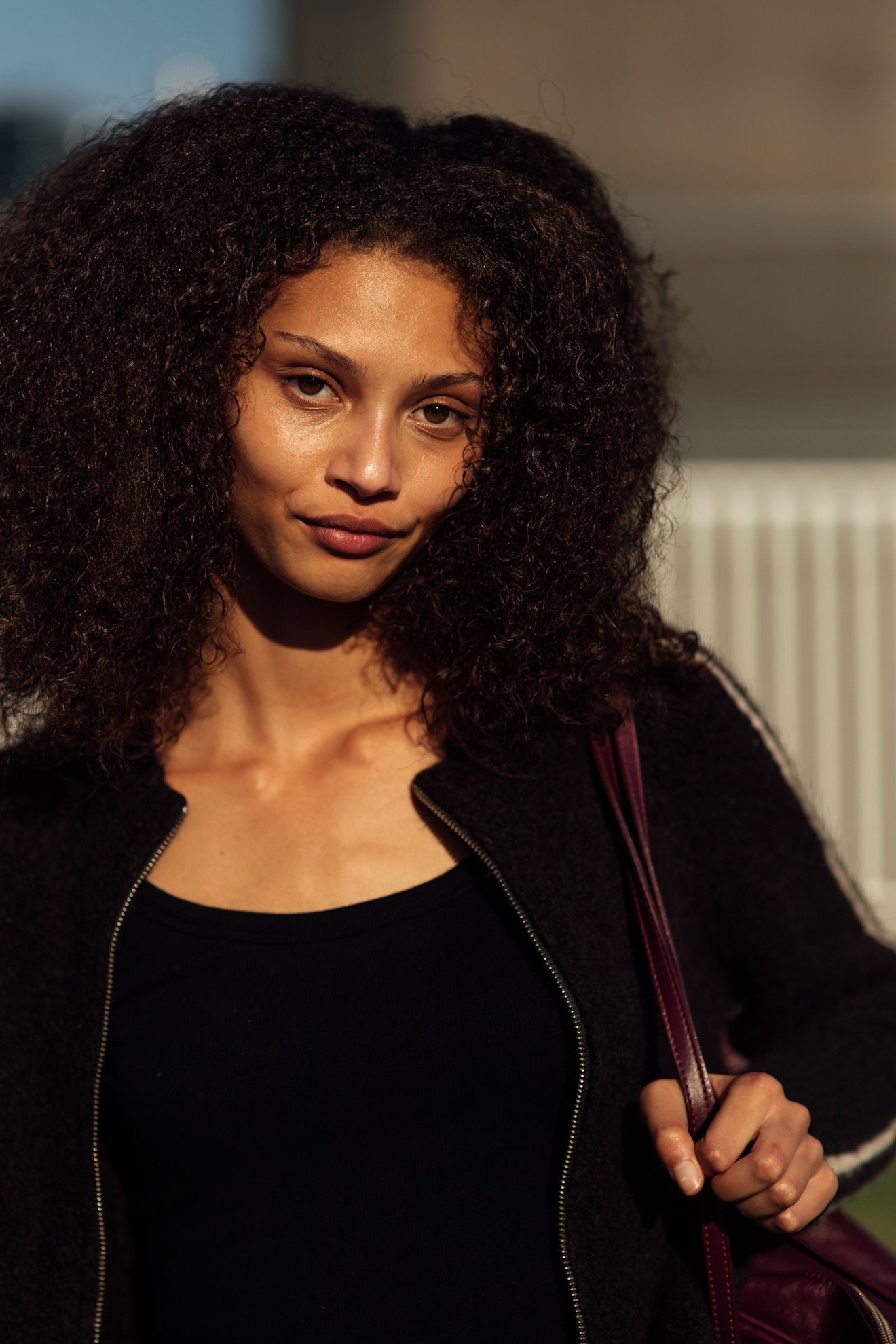 a black woman with voluminous curls in a black jacket