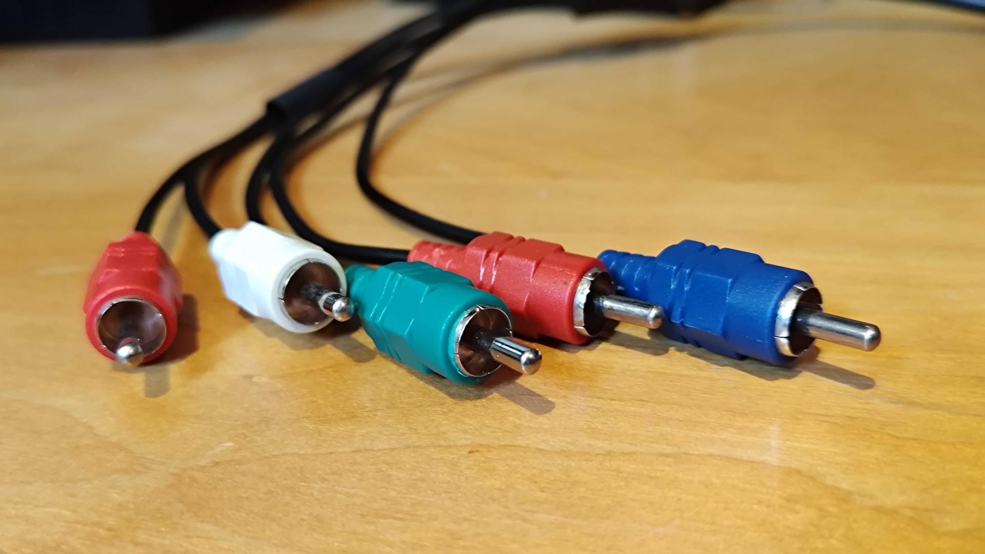 component cables in red, white, green, and blue on woodgrain surface.