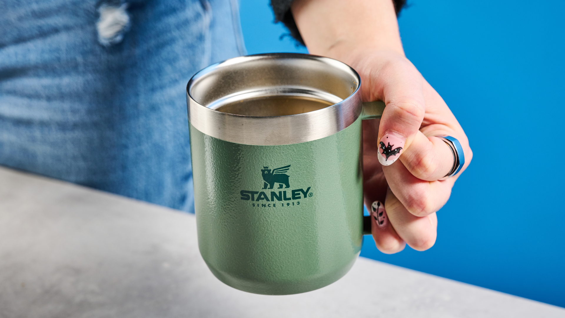 the stanley perfect brew pour over coffee maker in green, photographed with its companion travel mug and with the metal built in filter