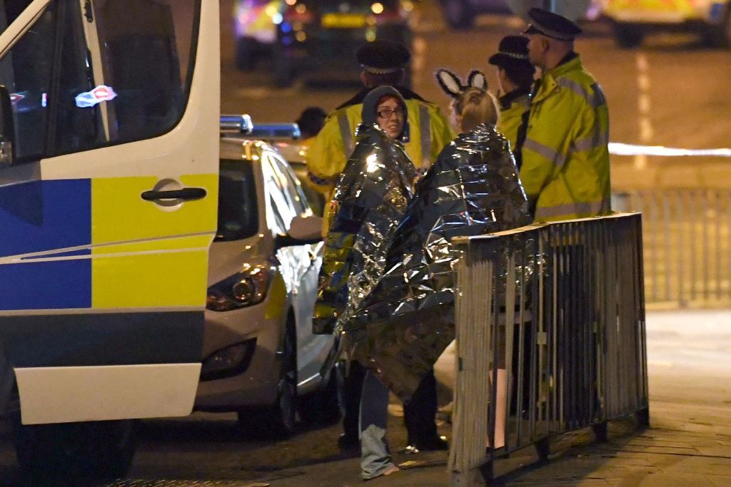 Concergoers huddle after explosion at Ariana Grande concert